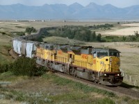 Eastbound grain empties with UP run through power from Portland Oregon to Enderlin ND Via Kingsgate and North Portal comes off the Crowsnest Pass and crosses the Peigan Reservation west of Fort Macleod 
