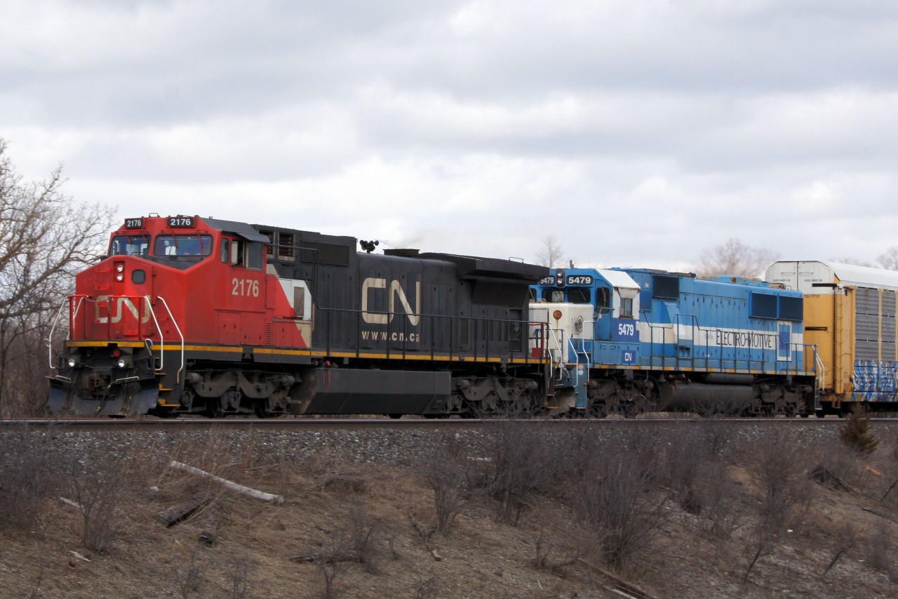 I was at Snider when I heard 393 call himself out of Mac Yard with the 2176 leading. Knowing that I required a photo of 2176 I raced over to this location. While I was driving, I received a heads up that the trailing unit was worth shooting as well, so my gamble of heading over here paid off. Little did I know that it would pay off in triplicate due to the next two westbounds, which were equally as interesting as this train. Unfortunately, a rogue cloud became aware that I was waiting for this shot, and just seconds before the train passed the sun was blocked. Naturally, the cloud moved on moments after the power passed by. 

It will be interesting to see how long the second batch of patched Oakway SD60s remains in service before being promptly repainted, and if any other used SD60s are on the horizon for CN.