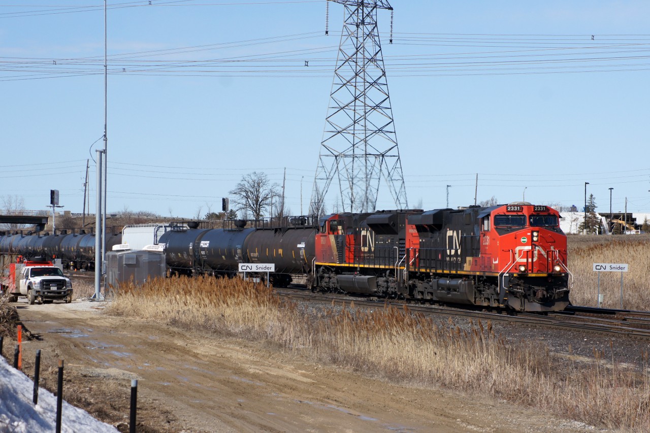 Despite today being a holiday there is no shortage of action at Snider. Crews are demolishing a warehouse west of Keele Street (visible in the background), CN staff is maintaining equipment at the switch plant, and trains are rolling by, such as this eastbound seen passing between the CN Snider signs. Behind the head end power are 113 cars, then the IC 1005 as a DPU, and another 41 cars trailing it.