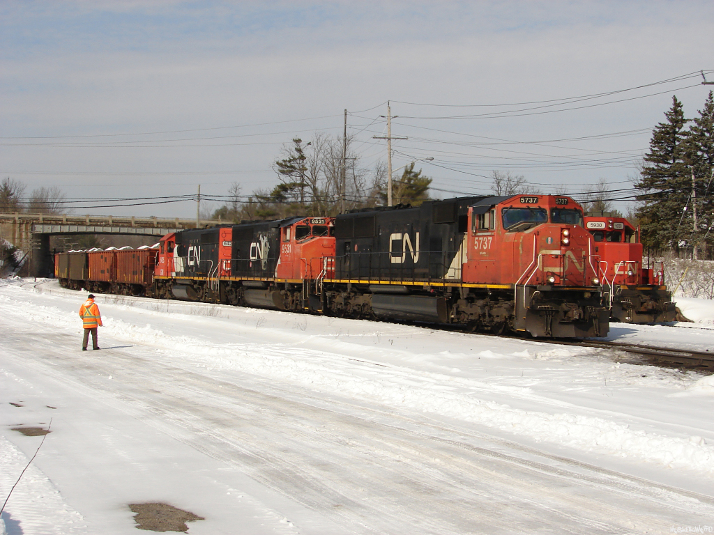 CN X31431 26 - CN 5737 South receives a PK inspection from the crew of W90831 26 seen tucked away beside them on the Newmarket sub waiting for L59531 26 to clear the block ahed in Gravenhurst before shoving Northwards to dump some rail on the Newmarket sub. Adding a little fun to their so far slow and boring day, the engineer and conductor of W908 started a snowball fight over the top of X314 with each other during the roll by!