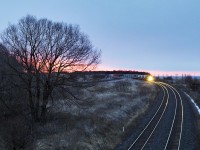 CN Q107's lead widecab illuminates steel rail on a dark Lovekin morning