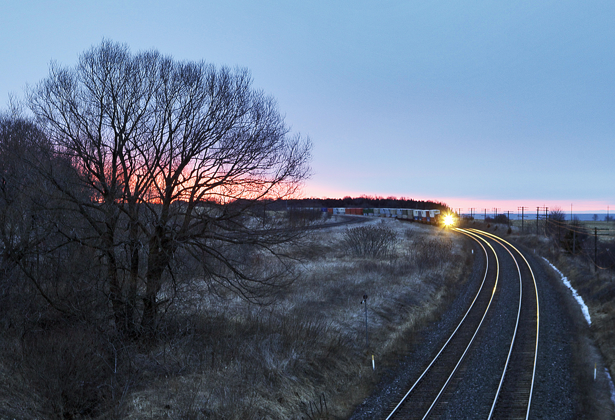CN Q107's lead widecab illuminates steel rail on a dark Lovekin morning