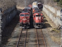 <b>Numberboard misfits:</b> CP trains 546 (Right) and Train 246 (left) both with mismatched numberboards sit side by side at Locke on the CP Hamilton Sub - the former Toronto Hamilton and Buffalo Railway. 546 sits waiting for a crew and 246 is about to pull clear of the west leg of the Waterford sub wye to back into aberdeen with a cut of coil cars.<br><br>Are the spartan numberboards a sign of Hunter Harrison's leaner CP?