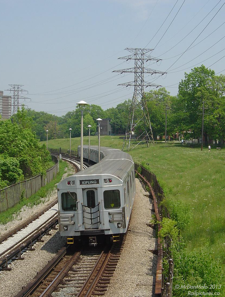 Over 7 decades ago...
A warm spring day finds a 6-pack of TTC subway cars heading eastbound along the Bloor-Danforth line's eastern section open cut, between Victoria Park and Warden subway stations. 20 minutes later, the same train will be heading back west after turning at Kennedy Station. People enjoying a leisurely stroll at the nearby Prairie Drive Park pay no attention, likely used to the rumbling of the subway through Oakridge (Scarborough).

While a hydro corridor and subway line inhabit this open stretch in the photo, nearly 80 years before a railway line ran through here: the old Canadian Northern Railways (CNoR) Trenton Subdivision (later renamed the Orono Sub) from Todmorden (in the Don Valley) to Ottawa. Once Canadian National (CN) took over the Grand Trunk and CNoR in 1923, much of this line was eventually abandoned due to duplicate rail lines in the area (the current CNR Kingston Sub to the south being the main one). It would be another 40 years until construction of a subway line in the 1960's began and rail returned.