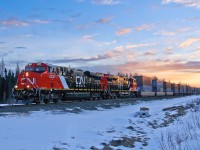 The sun begins to rise as brand new CN GE ES44ACs 2830 and 2829 speed up hill at Mile 160.2 of CN's Edson Sub with their second revenue train. They were put on train Q199 at Winnipeg after bringing in trains Q107 and M313 respectively, from Toronto.