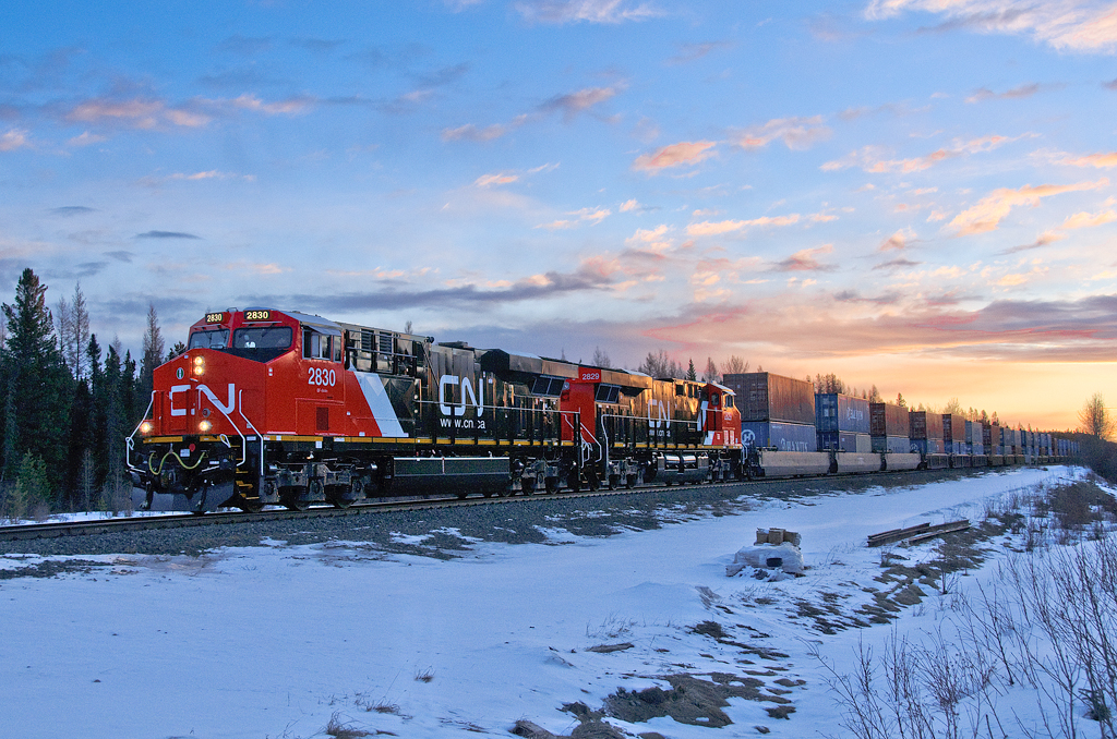 The sun begins to rise as brand new CN GE ES44ACs 2830 and 2829 speed up hill at Mile 160.2 of CN's Edson Sub with their second revenue train. They were put on train Q199 at Winnipeg after bringing in trains Q107 and M313 respectively, from Toronto.