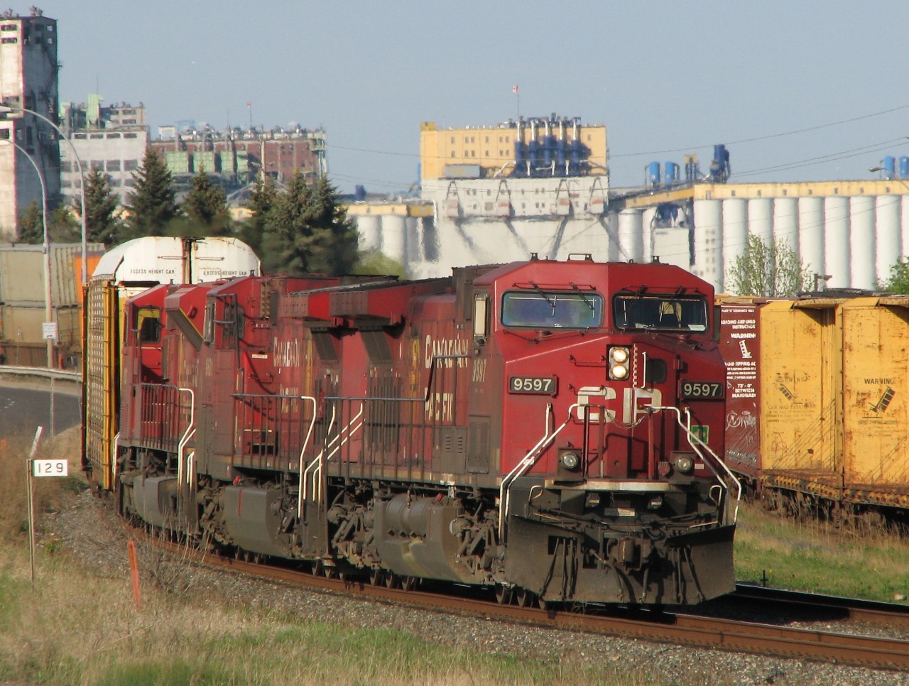 The stately grain elevators of JRI [James Richardson International] along the shore of Lake Superior on the 'Port Arthur' side of Thunder Bay provide the backdrop. A pair of AC4400CW's - cp9597 and cp9621 along with SD90MAC 9153 lead hotshot train CP#103. No remotes or distributed power back then! For the next mile the tracks are hemmed in by Fort William road on one side and CN's Thunder Bay North yard on the other.