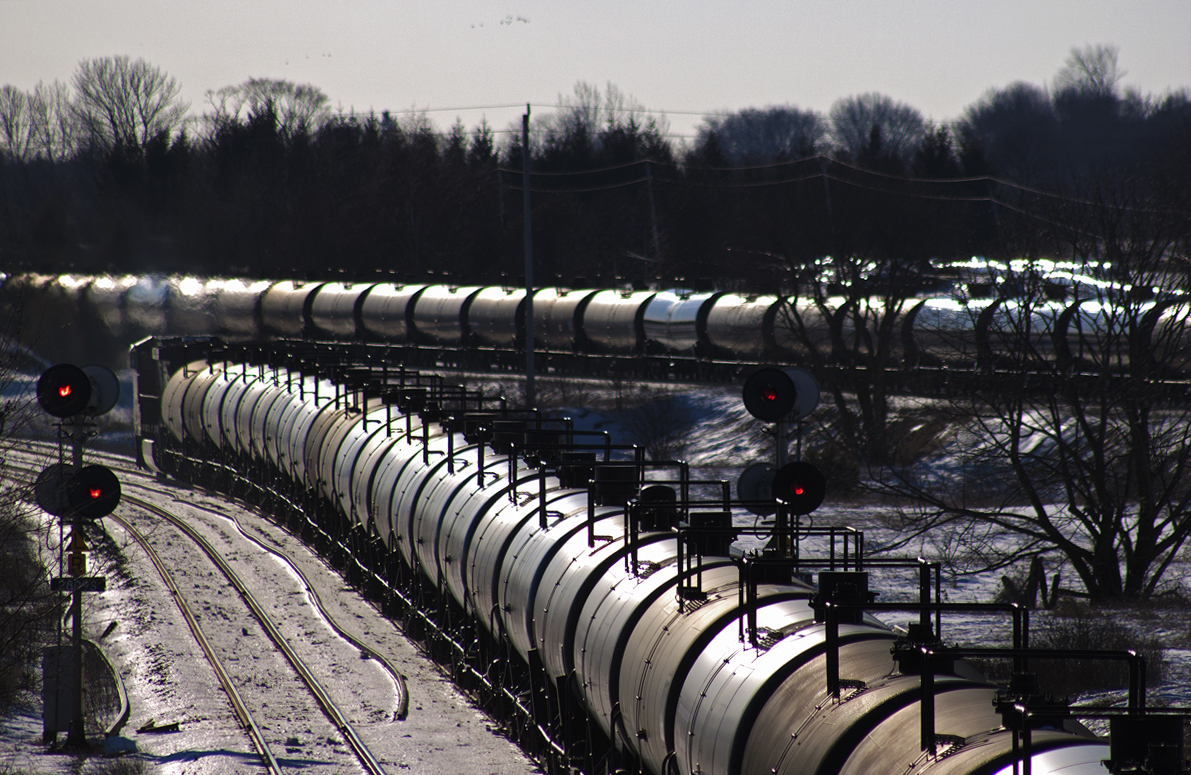 Sometimes a foamer just has to get lucky. I had been striving to get a shot like this for a few years now and the rail gods finally gave me my wish. Seen here is CN 305's freight (foreground) of Jet Fuel bound for Toronto (I think, more info is appreciated). In the background, CP 609 roars by hauling empty oil cans bound for the Bakken oil fields to be refilled.