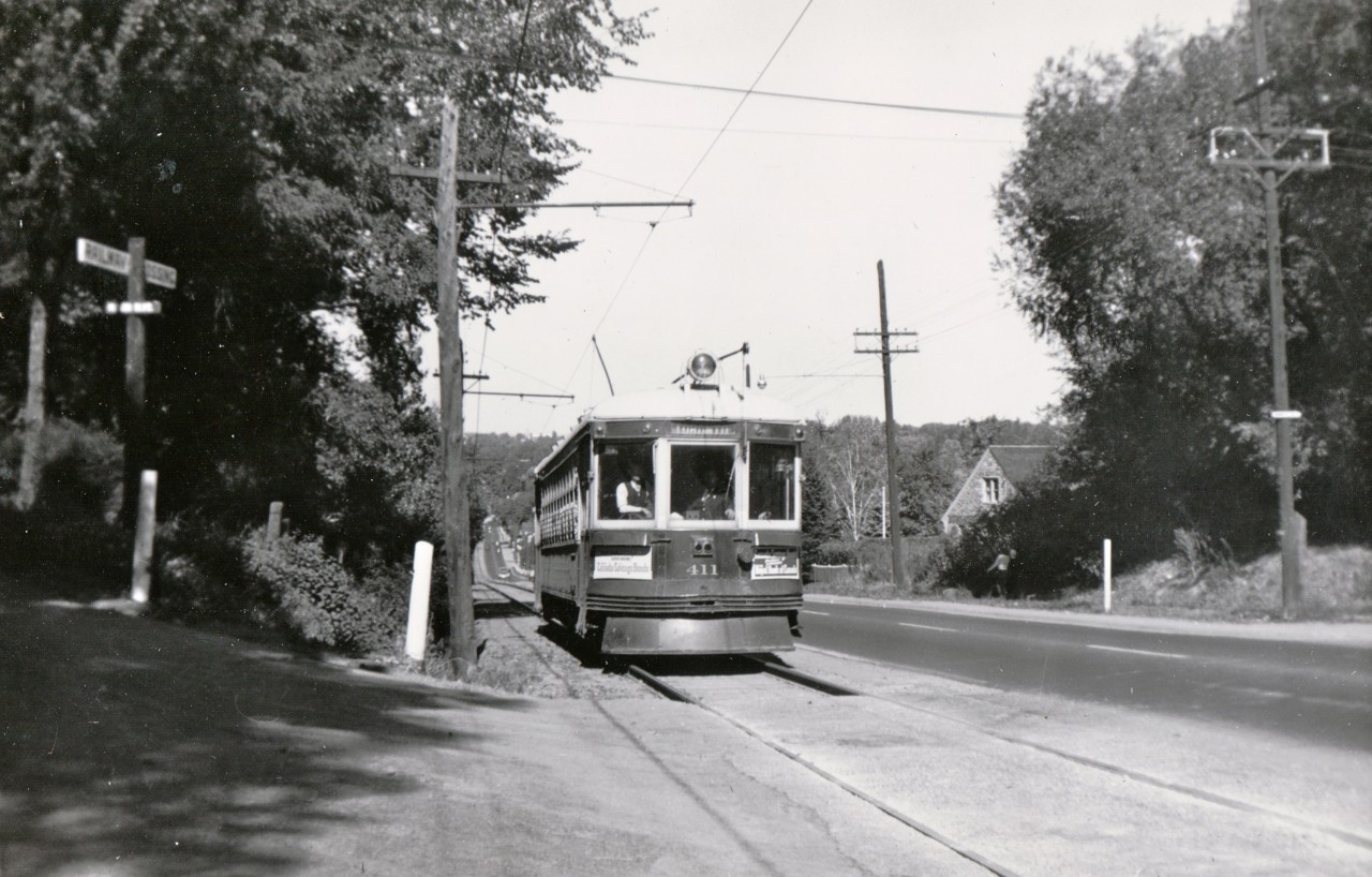 Toronto Transportation Commission 411 is southbound on the North Yonge line nearing the crest of Hogg's Hollow hill; in a few moments it will swing east across Yonge Street into the Glen Echo terminal located at what was then the boundary between North York and Toronto.  After the closure in 1930 of the former Toronto & York Radial Railway which extended from Toronto to Lake Simcoe, the townships of North York, Markham and Vaughan and the town of Richmond Hill banded together to acquire the southern 10 miles of the line to be operated by the TTC.  Except for street running through Richmond Hill, the entire route was on a private right-of-way, most of it on the side of the road.  Operations ended, replaced by buses, one week after the photo was taken, on October 10, 1948.  This photo appeared in Railroad Magazine in a 1949 story about the closure of the last remnant of the Toronto & York Radial Railway and in a 1980s calendar of the Upper Canada Railway Society.