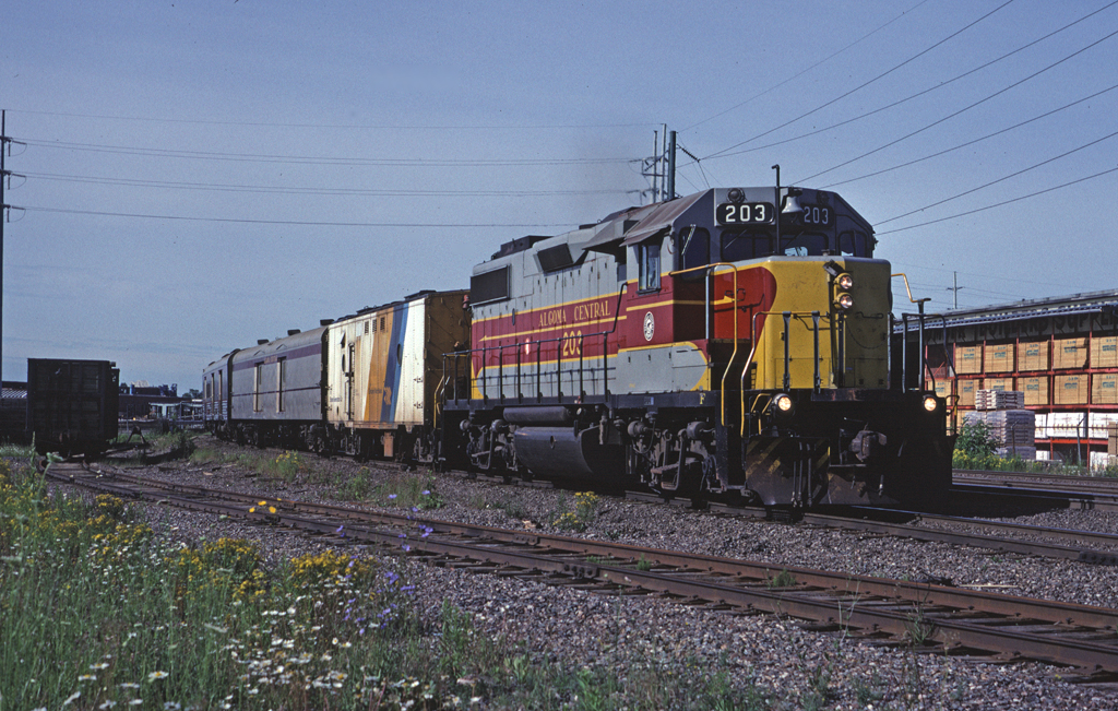 GP38-2 203 leads Sault Ste. Marie - Hearst train #1 through the urban area of the Soo before striking out into the northern Ontario wilderness. A leased Ontario Northland steam generator is providing steam for today's train.