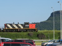Rolling past the towering Mount MaKay in the background and the Thunder Bay International Airport in the foreground, CN GMD1 1435 rolls by automobiles not even 1/4 of her age on a crosstown grain transfer, from Port Arthur to the Neebing area.