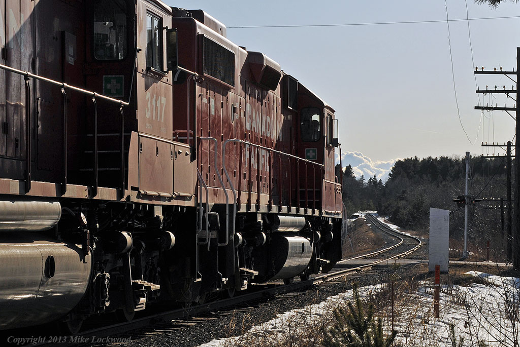 CP TO7 blows for the Old Scugog Road crossing at Burketon. Although the road signs proclaim Burketon, the Railway once knew it as Burketon Station, and it held the status of a junction point, being where the Lindsay, Bobcaygeon, and Pontypool Rwy started it trek north. That all ended in the late 1930's, but you can still see the wye and RofW heading north off the present trackage between Hwy 57 and Old Scugog on satellite imagery. CP3057, 3117, 3114, and 8233 power today's train. 1752hrs.