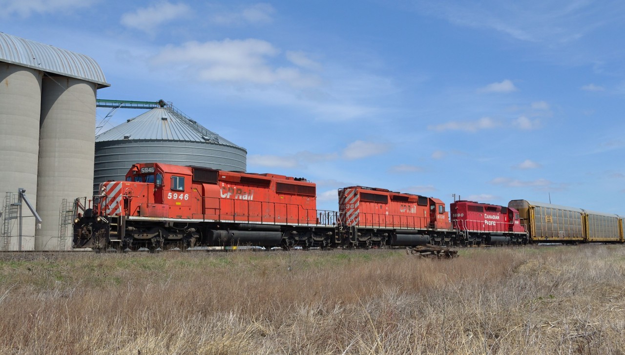 CP 235 heads westbound by the grain elevator at Haycroft with a trio of EMD SD40-2's