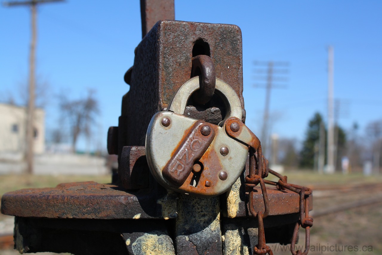 The main purpose of a lock is to keep something safe, whether it is locking your front door or your car.  In the case of this lock it is keeping a switch safe on the CN Hagersville Subdivision in Caledonia Ontario.  This lock has been protecting this switch for a long time, it has been here for so long that the cover with the CNR lettering has rusted in its current position but the lock still functions as if it was new.  It has seen a lot of different paint schemes over the years and soon it will be seeing the Orange and Black of Genesee and Wyoming.  While so many things change over the years this lock has remained them same.