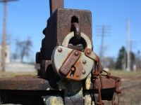 The main purpose of a lock is to keep something safe, whether it is locking your front door or your car.  In the case of this lock it is keeping a switch safe on the CN Hagersville Subdivision in Caledonia Ontario.  This lock has been protecting this switch for a long time, it has been here for so long that the cover with the CNR lettering has rusted in its current position but the lock still functions as if it was new.  It has seen a lot of different paint schemes over the years and soon it will be seeing the Orange and Black of Genesee and Wyoming.  While so many things change over the years this lock has remained the same.