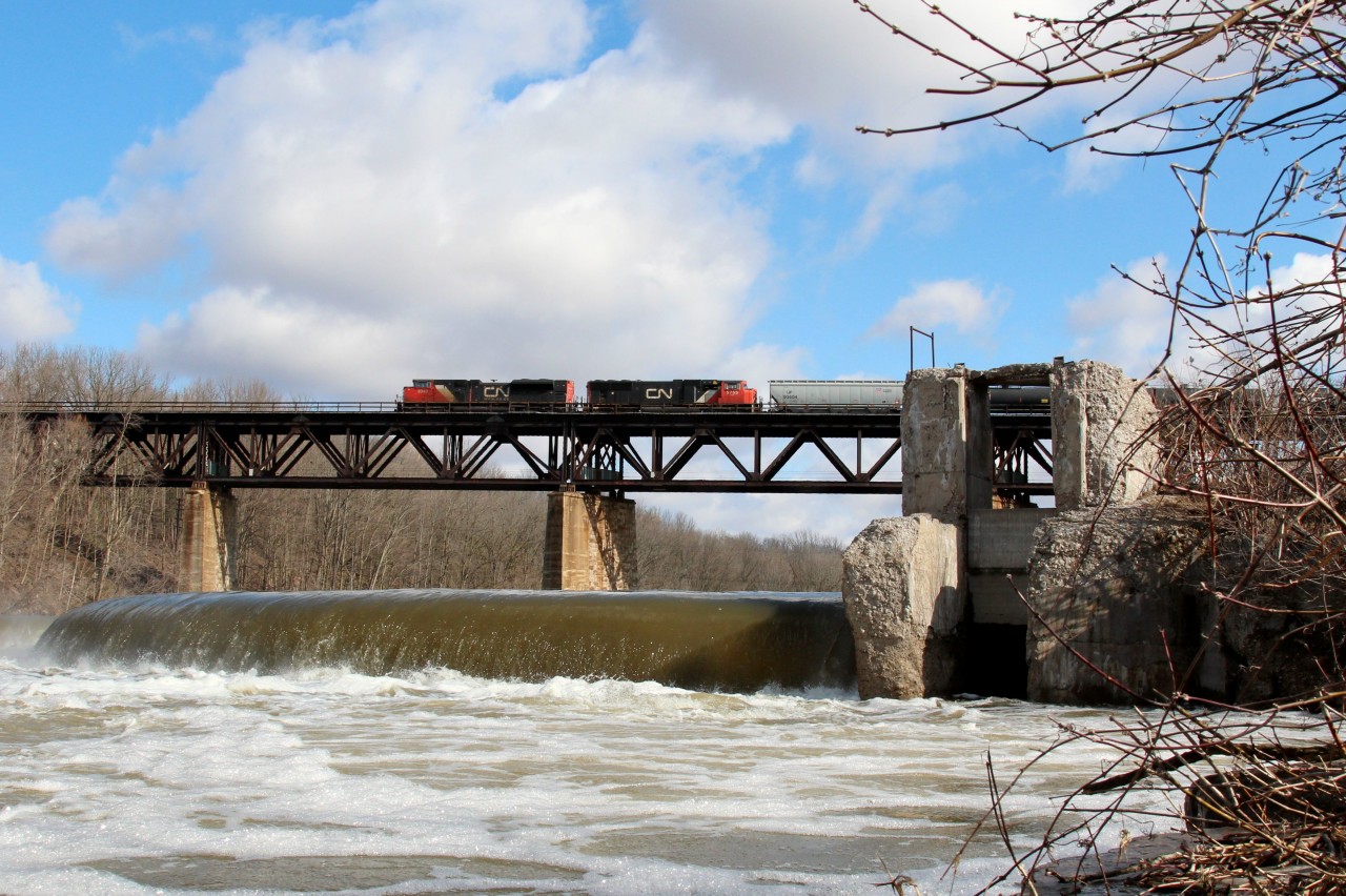 After several days of rain and spring runoff, the water level on the Grand River is quite high as C.N. 8949 leads a westbound freight over the trestle at Paris, Ont.