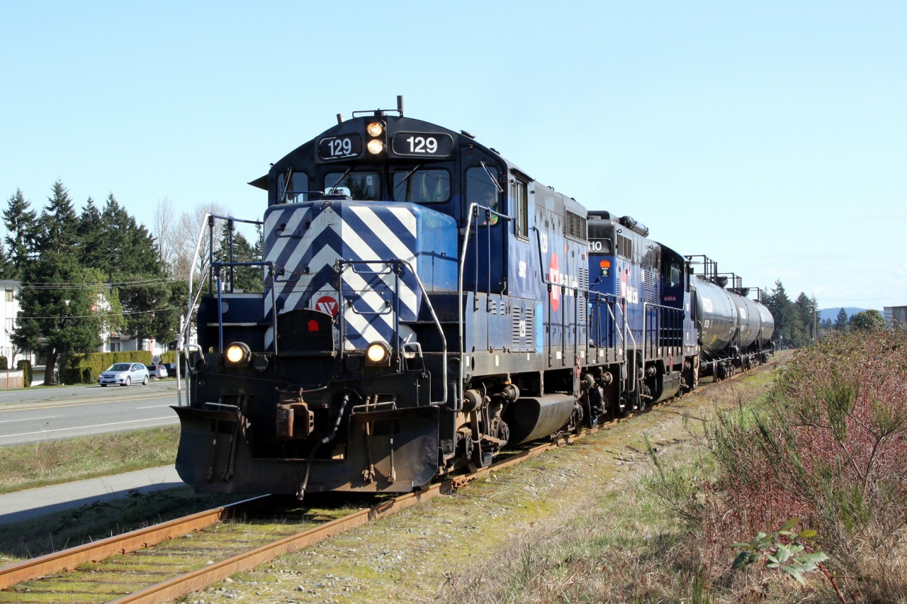 GP7 SRY 129,(ex-MRL 129, exx-C&NW 4376, nee SLSF), with GP9 SRY 110 approach Superior Propane on the Island Highway at Nanaimo with their train of 3 tank cars.