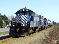 GP7 SRY 129,(ex-MRL 129, exx-C&NW 4376, nee SLSF), with GP9 SRY 110 approach Superior Propane on the Island Highway at Nanaimo with their train of 3 tank cars.