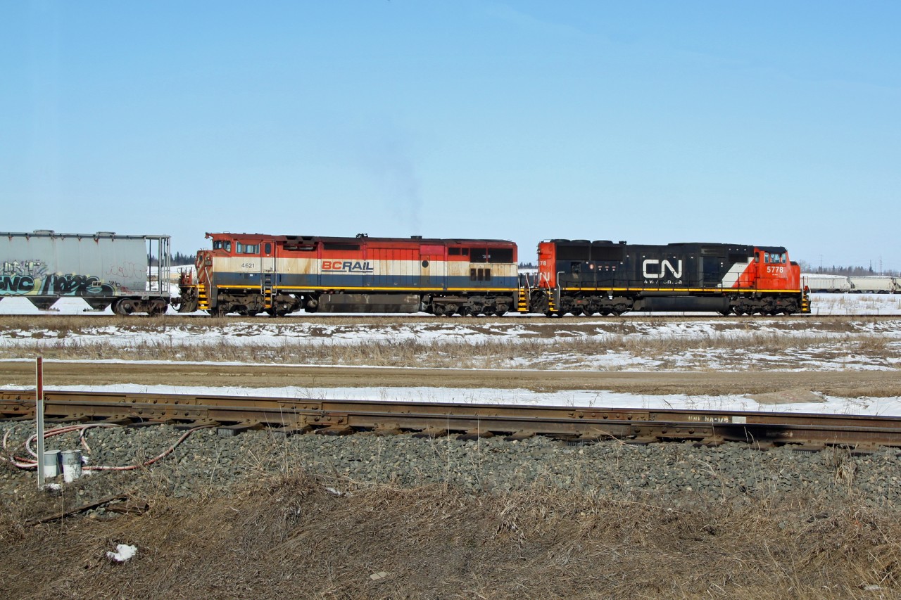 Not seen often these days a BC rail loco in the old red, white and blue stripes. SD 75i CN 5778 and Dash 8-40CMu BCOL 4621 use the Scotford Industrial Lead to pull through the yard before splitting their train for parking.