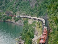 Hotshot train #482 with a trio of SD40-2's skirts the shore of Lake Superior on a right-of-way blasted out from the face of the rock cliffs. Note the ‘TOFC’ in the consist.