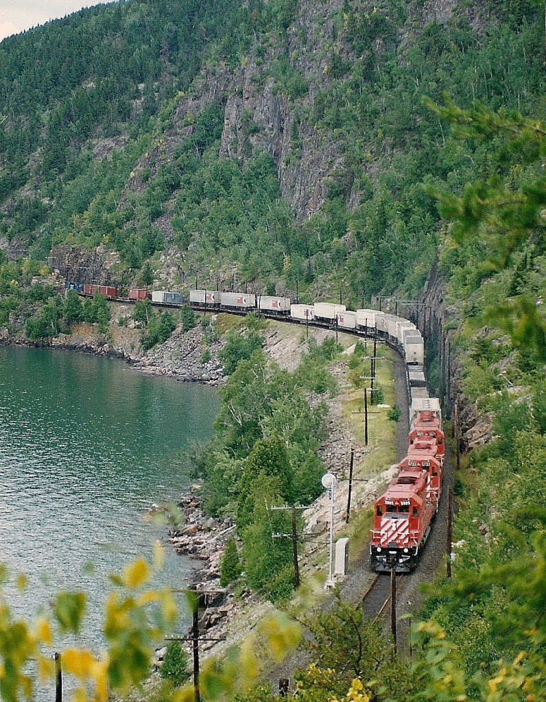 Hotshot train #482 with a trio of SD40-2's skirts the shore of Lake Superior on a right-of-way blasted out from the face of the rock cliffs. Note the ‘TOFC’ in the consist.