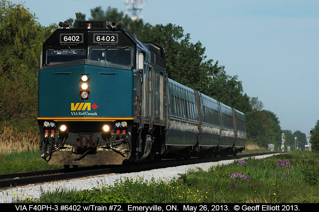 VIA 6402 has train #72 running at speed as it races through Emeryville, Ontario on a beautiful May morning.  Yellow and purple wildflowers are popping up around the ROW making a nice addition to the colors.