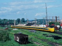 One of my favourites: Modern verses Historic: VIA Rail  #67 is  Turbo equipped today as the train cruises past the Port Hope station built 1856  by the Grand Trunk Railway. The CN freight shed is right behind the lead power unit. Note the interchange track in the foreground. At the middle left is CP Rail's Belleville Sub bridge over the Ganaraska River. Construction in the background is the infamous Eldorado Nuclear factory facilities (now owned and operated by Camenco ). Of course today a lot of what is in this image is also History. June 26, 1982 Kodachrome by S. Danko.<br><br>More Port Hope Station:<br><br><a href="http://www.railpictures.ca/?attachment_id=2116">  CN time at Port Hope  </a> <br><br>More Turbo:<br><br><a href="http://www.railpictures.ca/?attachment_id=6555">  near Scarborough  </a> 