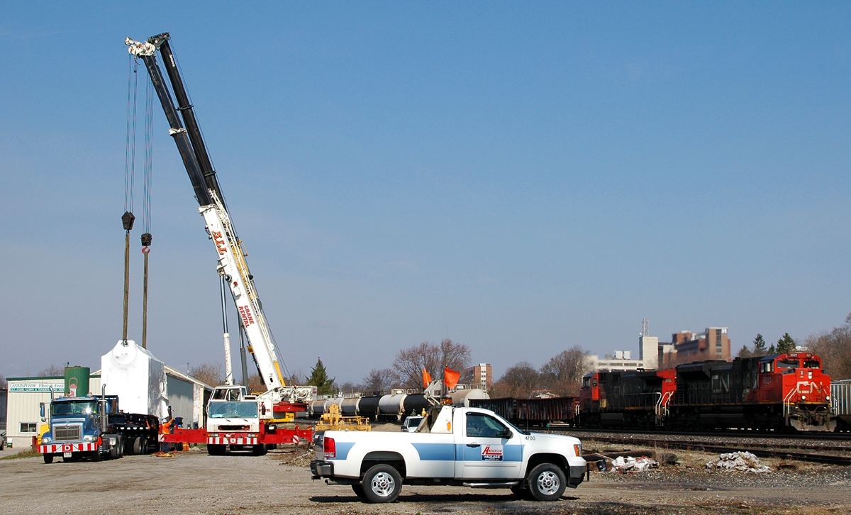 A Pair of Crane's from All Crane Rental in Clevland, OH work to unload a boiler for Ferrero Rocher. As 382 with CN 8821 - CN 2518 makes it's way past in the background