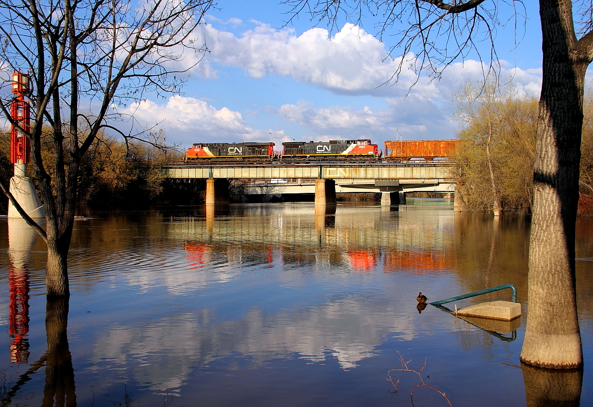 A westbound manifest crosses the Assiniboine River in downtown Winnipeg.
