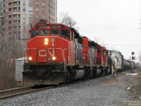 <b>Busy single track mainline.</b><br><br>Back before the double- and triple-tracking of the busy CN Halton Subdivision for expanded GO service, there was a stretch in Brampton between Kennedy Road and Queen Street that remained single tracked since at least the 1950's (between mileboards Peel and Brampton East, resp.). This section, while a bottleneck during busier times, offered the advantage of making sure one caught every train without the photographer getting hosed during meets.<br><br>On a slightly overcast day, in the span of just 15 minutes, that single track section presented a nice parade in the following order: CN #435 heading west with a pair of SD's and 3 Geeps, #392 motoring east with a Draper Taper leading a WC SD45 and IC SD40 (both Operation Lifesaver units), and finally our pictured #338 with a trio of SD40-2's riding his block. Wide-nosed SD40-2W CN 5338 and CN-painted IC SD40-2's 6200 & 6139 lead the charge east, past the AEI reader at Brampton East and over the dual James/John St. crossings.<br><br>The roadbed and bridge over Queen Street for the future double tracking here can be seen already in place, and crews were working to the east to clear the line for installing double tracking through this section, to come online a few years later in 2008/2009.