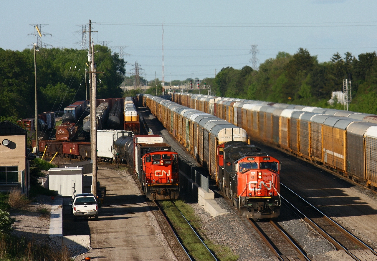 CN 399 pulls down track 34 past the yard crew at Aldershot yard. 399's consist included CN 5687, BC Rail 4646 and an idle 5703. 399's crew would set off 53 emtpy autoracks from Edmonton's Clover Bar yard destind for the Ford Oakville plant. They then picked up a dozen autoracks from the adjacent string and headed west.