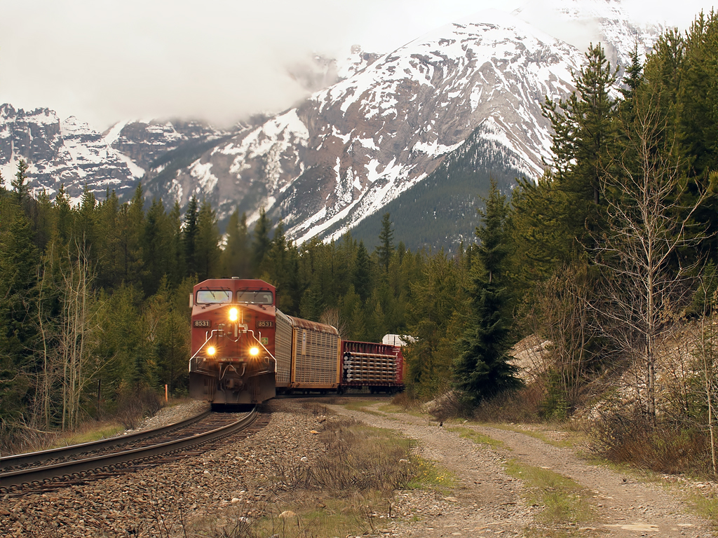 Walking just off the road waiting for a loaded grain train, and see the signal at Stephen shows an eastbound which sounds very close, I run to the edge of the gravel hillside to see if there is an angle for a shot. Then I lean a bit to far and find myself scrambling/falling down the hill trying not to tumble or drop my camera. Arriving at the bottom intact as this comes around the corner; I take the shot, and start climbing.