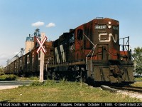 CN 4424, one of the last high hood GP9's on the CN roster, leads the Leamington Local through Staples, Ontario in October of 1988 with a long cut of Insulated Boxcars for Heinz in Leamington.