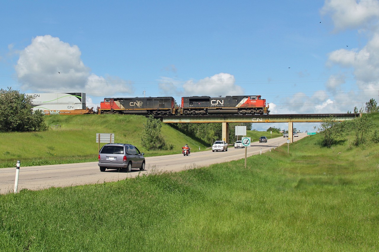 SD 70M-2 8020 and DASH 8-40CM 2440 cross a busy Hyw 37 on the Vegreville Sub at Fort Saskatchewan
