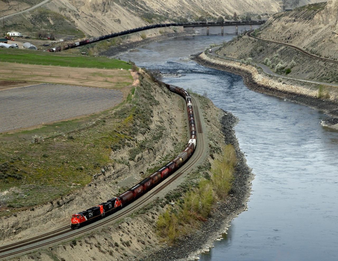 General freight 309 approaches the east switch to Ashcroft BC in the semi arid Thompson River valley. CP main is on opposite bank. Shared trackage starts about 10 miles west of here