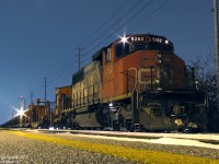 <b>A Hard Day's Night</b>
<br><br>
And after working like a dog all day laying rail along the Weston Sub, CN SD40-2W 5262 sits on point of the continuous welded rail (CWR) train, tied down for the night at the Malton GO Station. Sole power, the ratty 5262 has seen better days: its original 70's zebra stripe paint is now faded and rusty from many years of hard use. The CWR equipment behind it bears Transcona Shops (Winnipeg MB) logos, no doubt where it was built up from old flatcars by installing racks and winch equipment to facilitate picking up, storing, and laying long spaghetti-like strands of steel rail. In the distance, the eastbound signals at Woodbine West glow red, protecting the PM rush of westbound GO trains from any unauthorized track movements against them.
<br><br>
And the intrepid photographer, having gotten off the warm confines of the previous GO train for a shot or two, exposes a few more photos in the cold night before the next one home arrives.