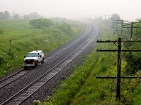 No train in sight to make the scene ? No problem, a hi-rail will do... Fog rolls in off Lake Ontario after a rain storm meanwhile an engineering foreman does a track inspection of the north track between trains.