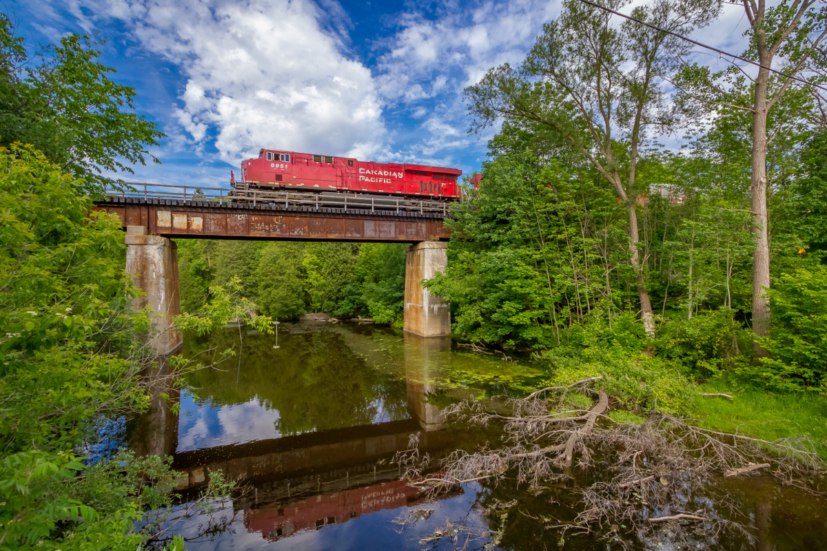 In this wide angle scene, CP 8951 thunders across the 102 year old trestle above the Bronte Creek in Progreston, ON. The town of Progreston was established around mills that were powered by the nearby waterfall. In the early 1900s Progreston had become a manufacturing centre, however, by the 1950s Progreston had deteriorated to only a handful of residences. Today Progreston remains as a hamlet, part of Carlisle and part of the even larger Hamilton Area.