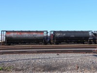 A pair of old pressure flow hoppers sit in the yard.