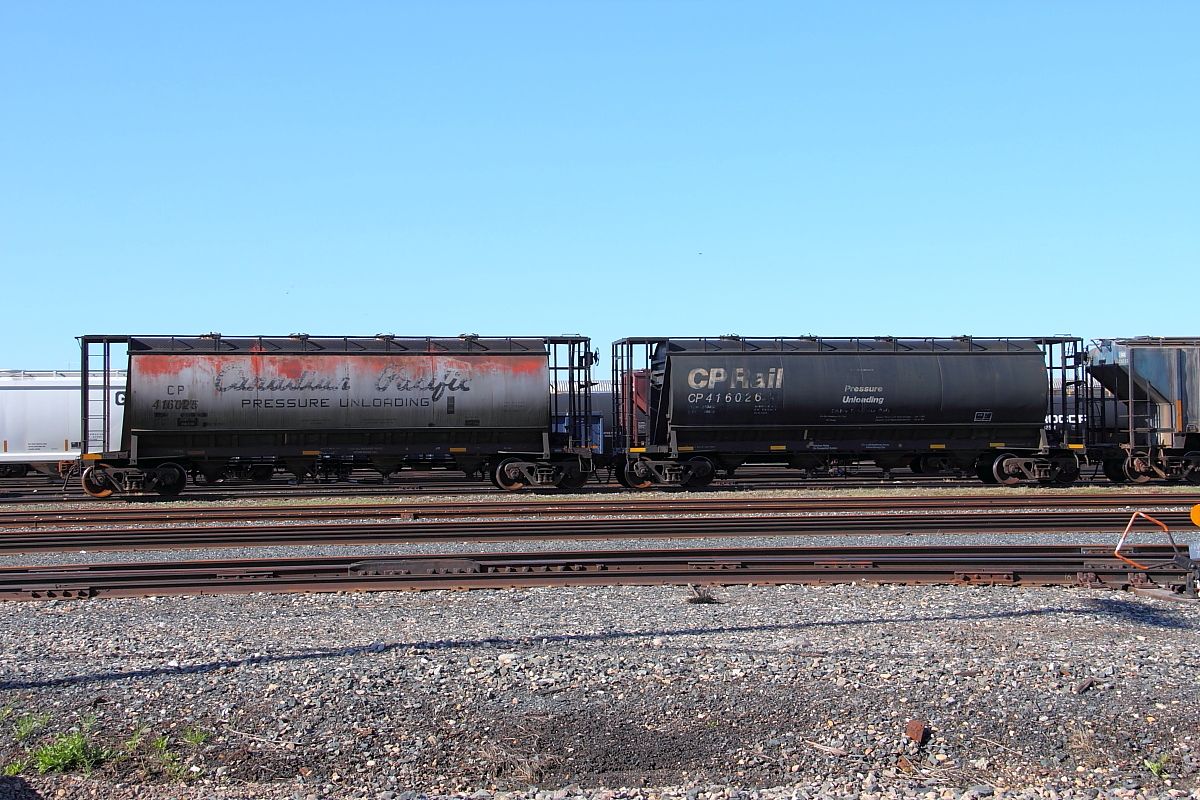A pair of old pressure flow hoppers sit in the yard.