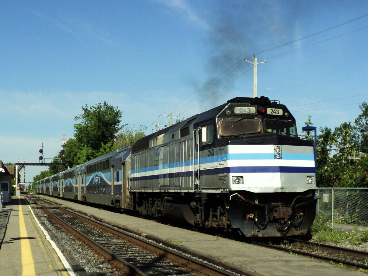 AMT leaving St-Lambert station for Montréal was coming from St-Hilaire control car in front 3000 in back loco 243 pushing smoking a bit