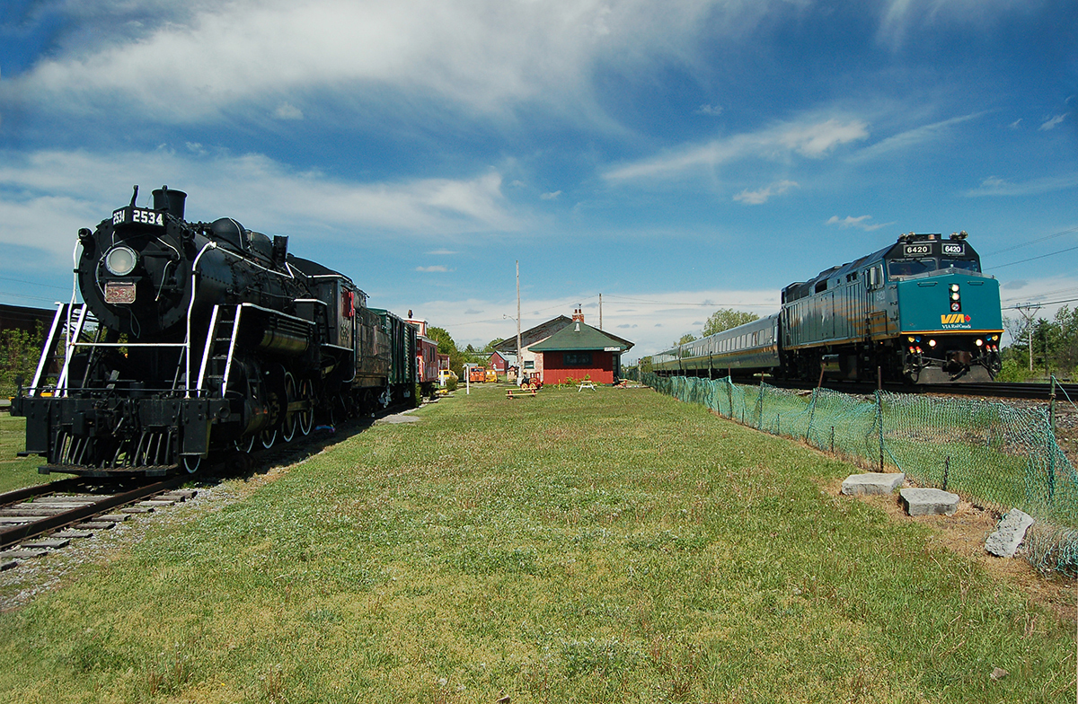 The old & the new. A westbound passenger train led by VIA F40PH-2 #6420 passes CN 2-8-0 #2534 on display at Memory Junction Museum in Brighton, ON. For more pics & video from my collection see northamericabyrail.info