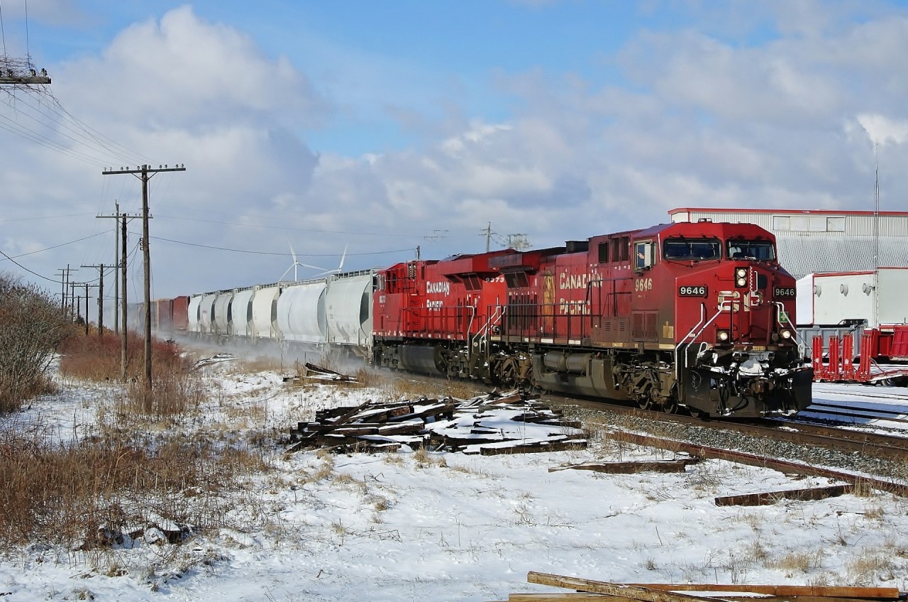 CP 9646 leading CP 9373 kicks up fresh snow on the first day of febuary as they pass through tilbury with the wave from the engineer.