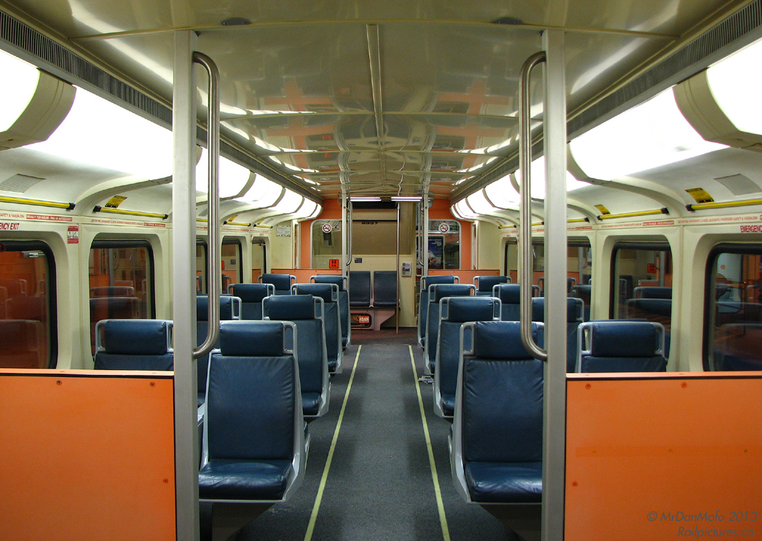 An afternoon commute wouldn't be complete with a ride on a late 80's orange bilevel passenger car. Built by the Urban Transportation Development Corporation (previously by Hawker Siddeley, now Bombardier) in 1988/89, GO Transit 2337 is still racking up the miles in her near-original interior decor, seen here empty before departing Toronto Union Station on afternoon train #263 to Bramalea. The photographer notes he would then take a seat near the front on the right, and enjoy the 35 minute trip home.

Fast forward a number of years, and an ongoing rebuilding/refurbishing program has updated most of GO Transits' older cars such as 2337 to a more modern look, with all of the screamin' orange panels and light blue vinyl seats replaced with subtle grey and deep blue fabric.