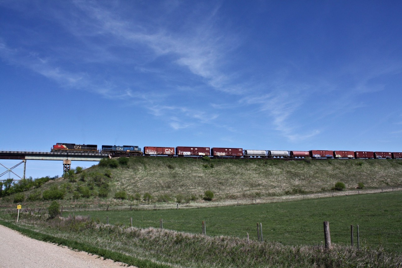 CN 403 with a CN and IC units are about cross the trestle at Rivers Manitoba.