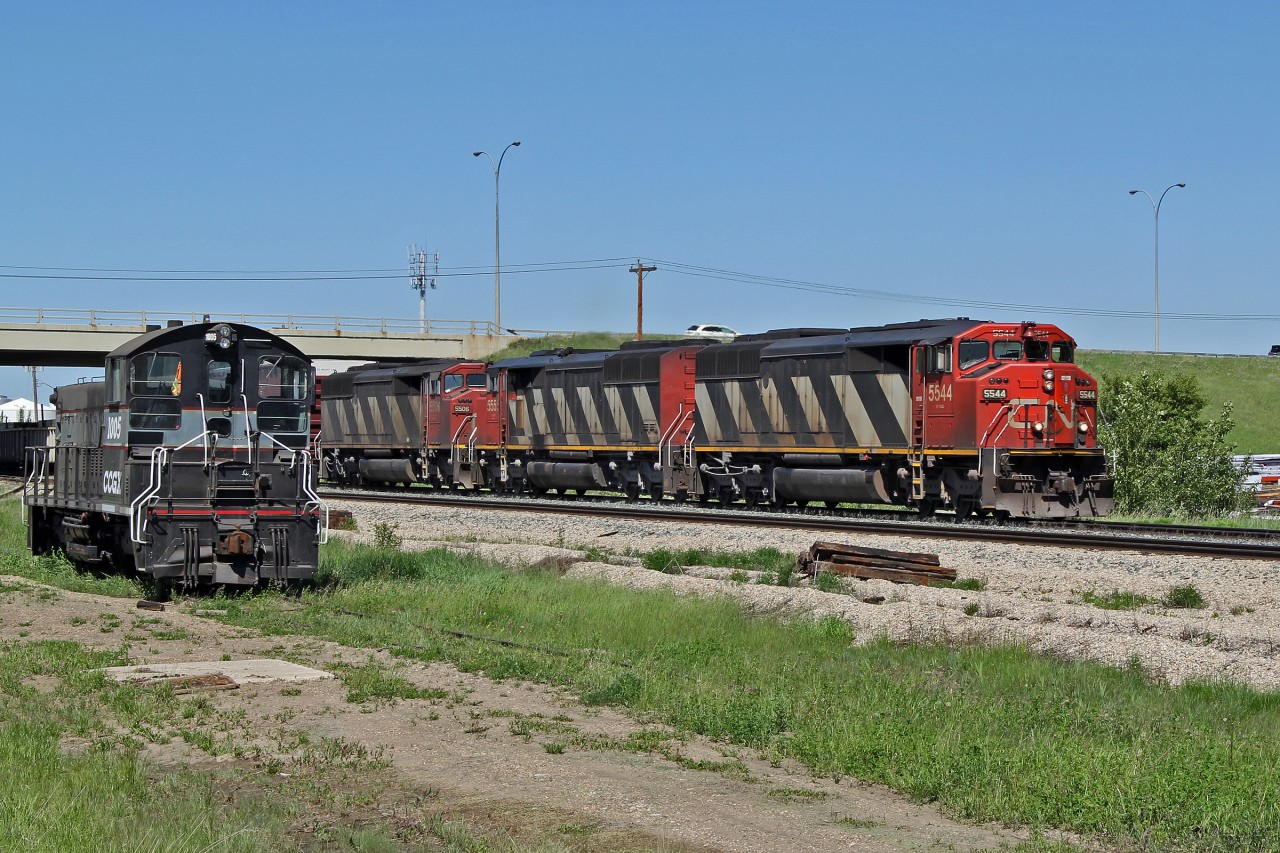 A trio of SD60F's, CN 5544, 5553 and 5506 head south on the Camrose Sub past the forlorn looking SW1200RSu Cando 1005