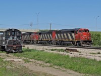 A trio of SD60F's, CN 5544, 5553 and 5506 head south on the Camrose Sub past the forlorn looking SW1200RSu Cando 1005