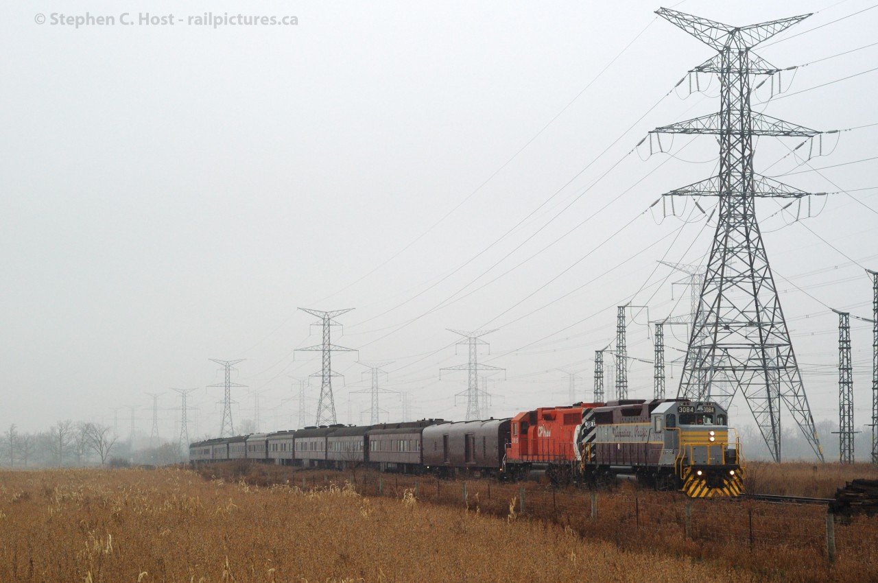 Royal Canadian Pacific  Passenger 3084 east, train 40B - is eastward en-route to Montreal be divided amongst the US and Canadian holiday trains. The train is climbing the grade out of the Hornby Dip while 500KV transmission lines buzz in protest to the 100% humidity. 30 minutes earlier this scene was engulfed in fog.