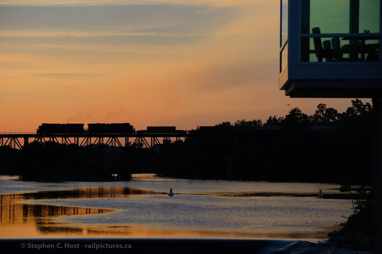 Smoke rises from a pair of GEVO's as a Westbound is charging out of Galt, Ontario at sunset. It seemed like I  was the only person watching this event unfold, as the empty Cambridge  Mill restaurant seats attest to. Photo data: f/5.6, 1/1250s ISO 400.