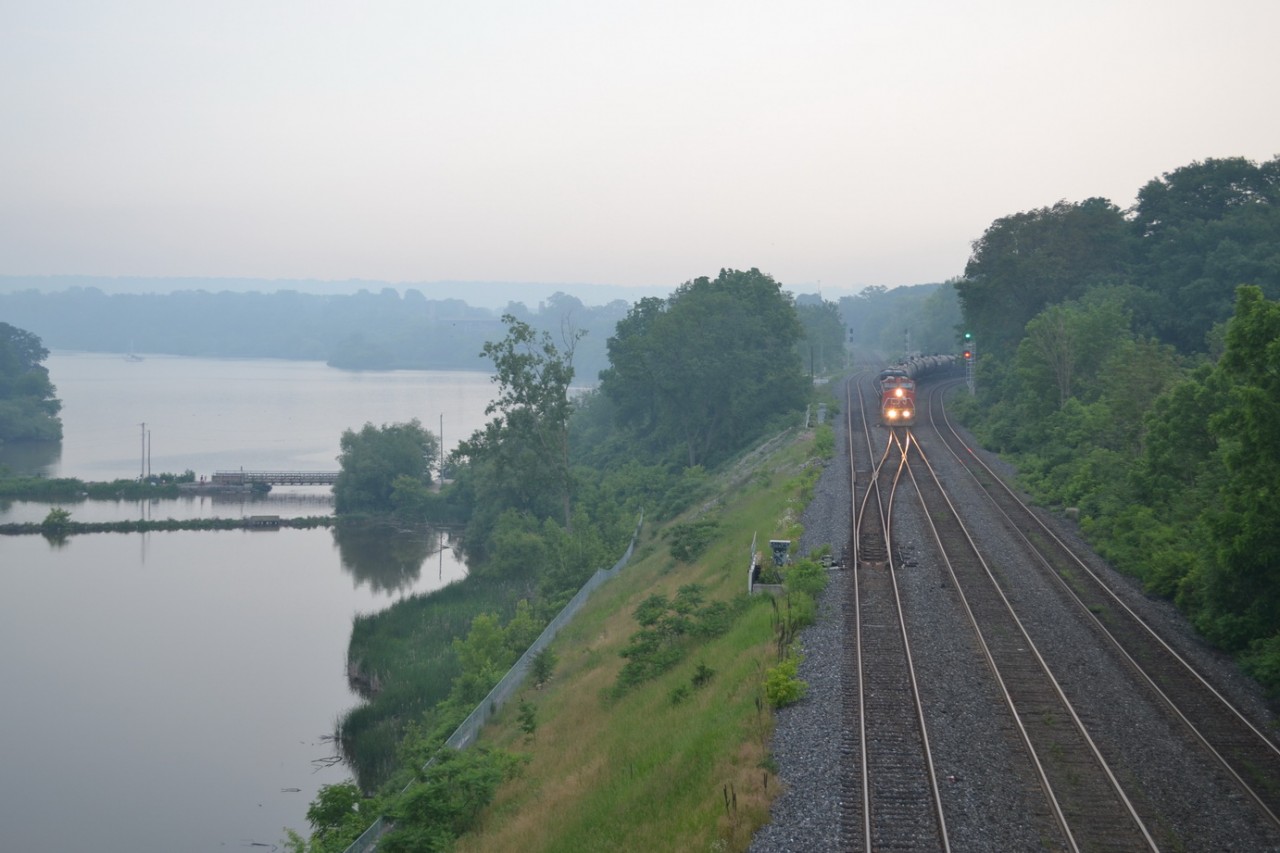 CN train L394 comes down the Dundas sunb, and onto the Oakville sub, with CN 2190 and CN 2455, just after a small pop up shower had ran through. The rain brought down the temperature, and created a nice haze across the water and the land. CN L394 is 95% crude oil cars, but most of its train was set off in London Yard, with Windmill parts for Chatham Ontario.